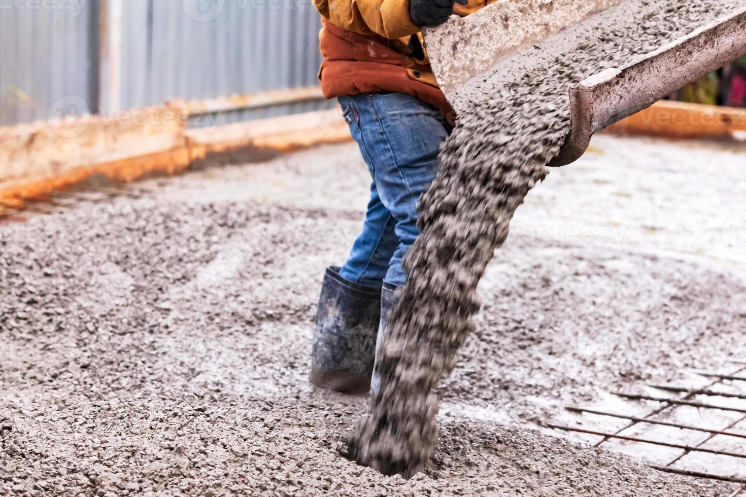 Closeup shot of concrete casting on reinforcing metal bars of floor in industrial construction site photo