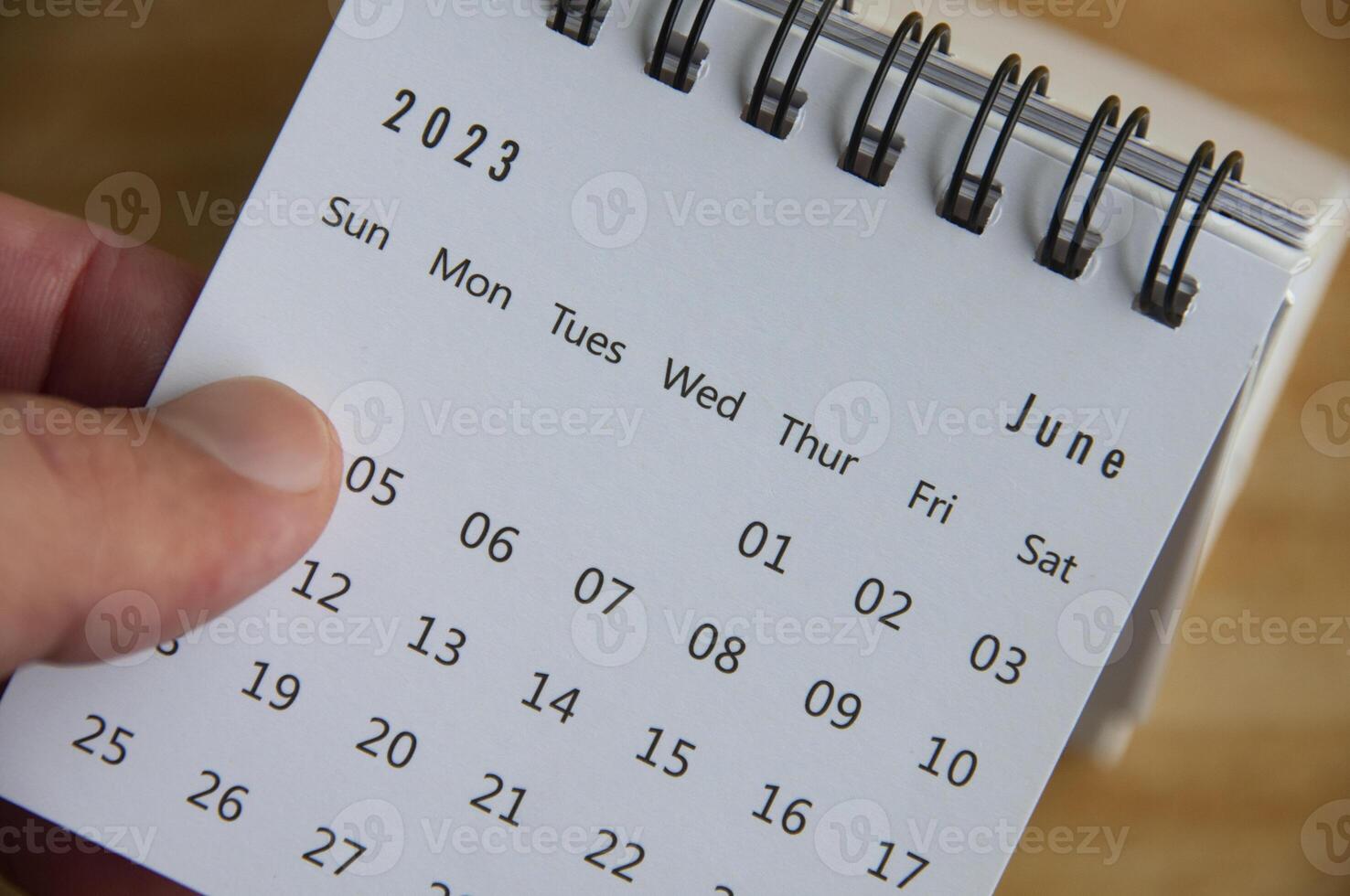 Top view of hand flipping June 2023 calendar. Calendar concept photo