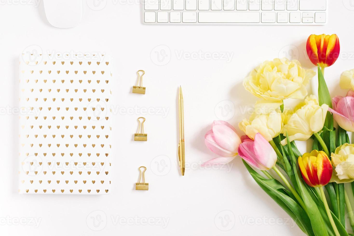 Festive spring composition tulips, a notebook with a pen, on a white background. the concept of spring holidays of a freelancer or blogger photo