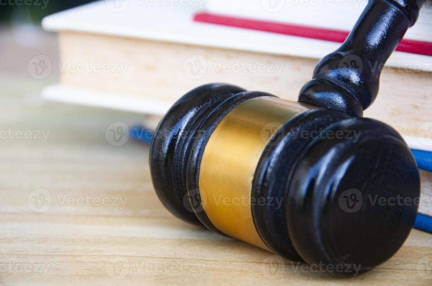 Close up of Lawyer's gavel on wooden table with stack of books background. Copy space and law concept photo