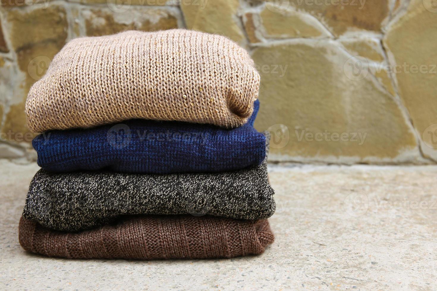 Pile of warm clothes on stone background. photo