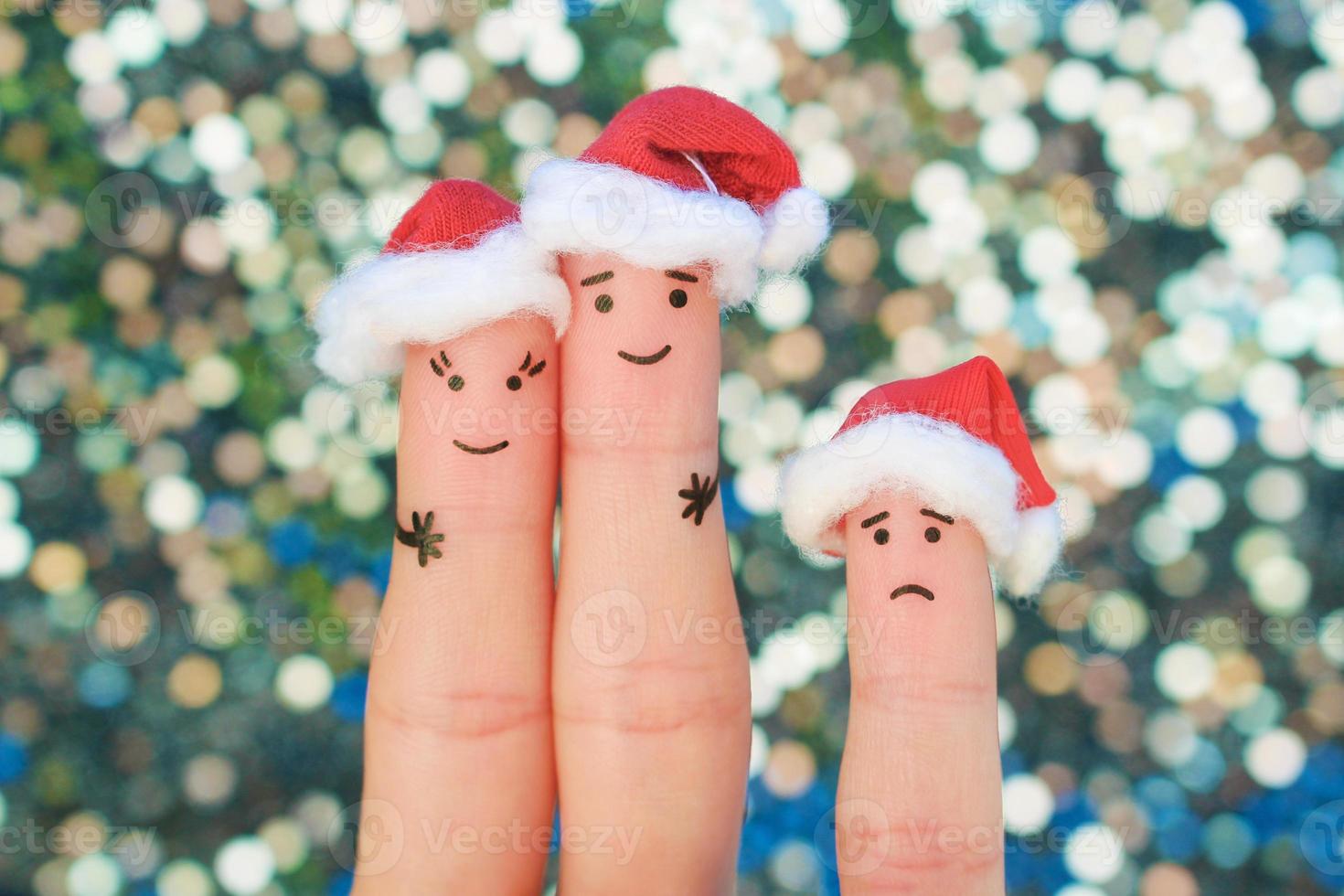 Fingers art of happy couple laughing in New Year hats. Man and woman hugs. Child is angry. Fingers art of couple celebrates Christmas. photo