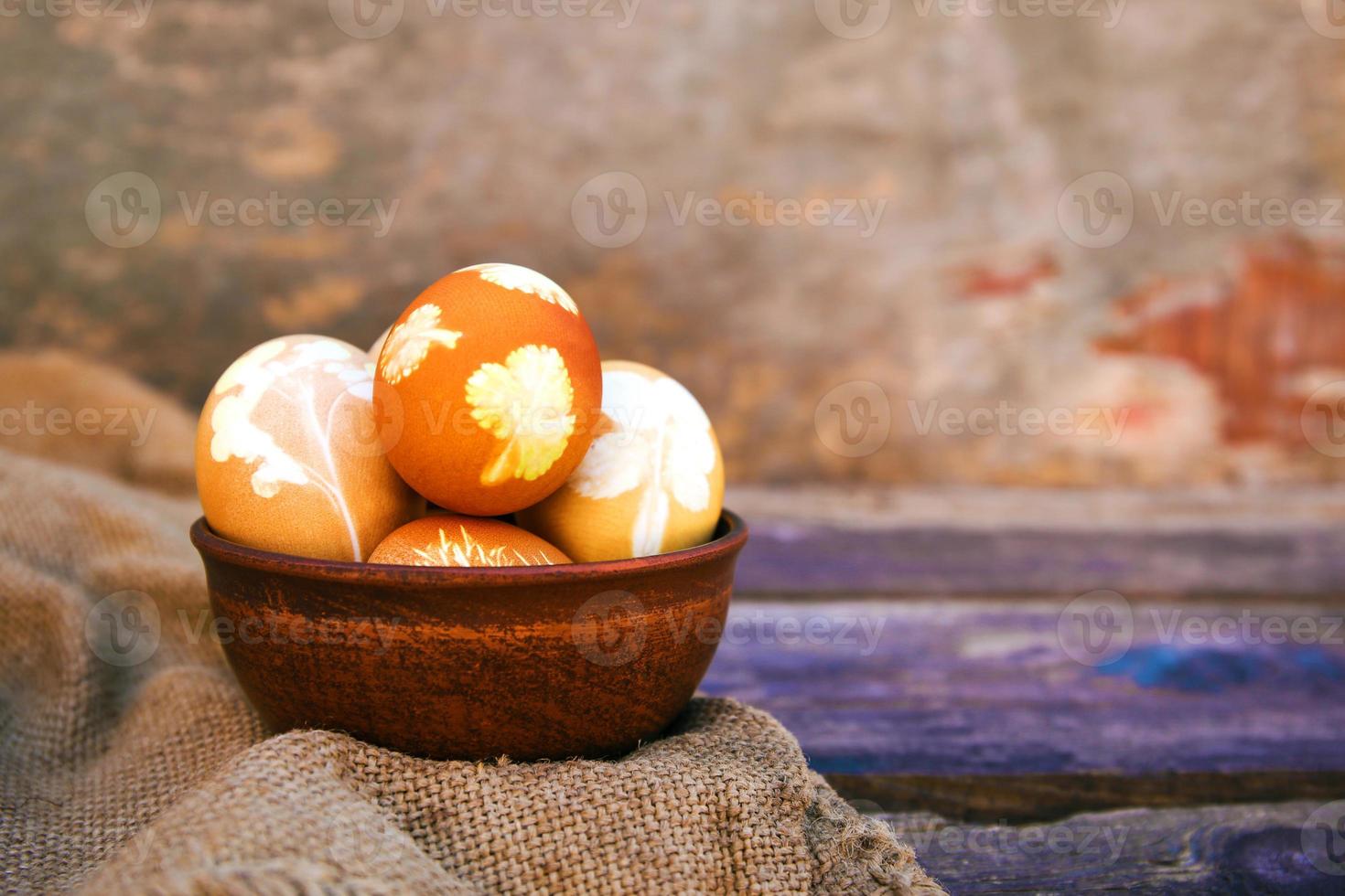 Easter eggs with pattern colored with onion peel on old wooden background. photo