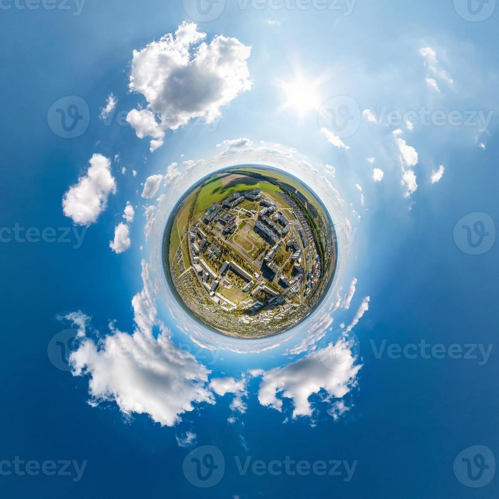 tiny planet in sky with clouds overlooking old town, urban development, historic buildings and crossroads. Transformation of spherical 360 panorama in abstract aerial view. photo