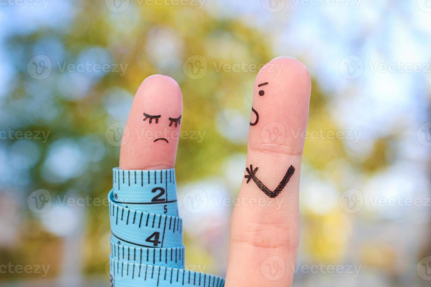 Fingers art of couple with meter. Concept husband is angry that his wife can not lose weight. photo