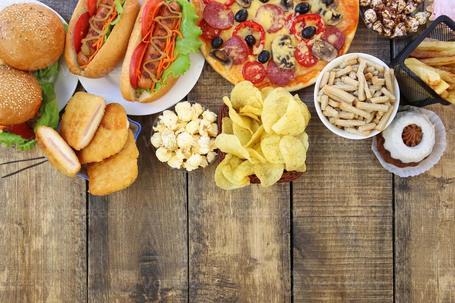 Fast food on old wooden background. Concept of junk eating. Top view. Flat lay. photo