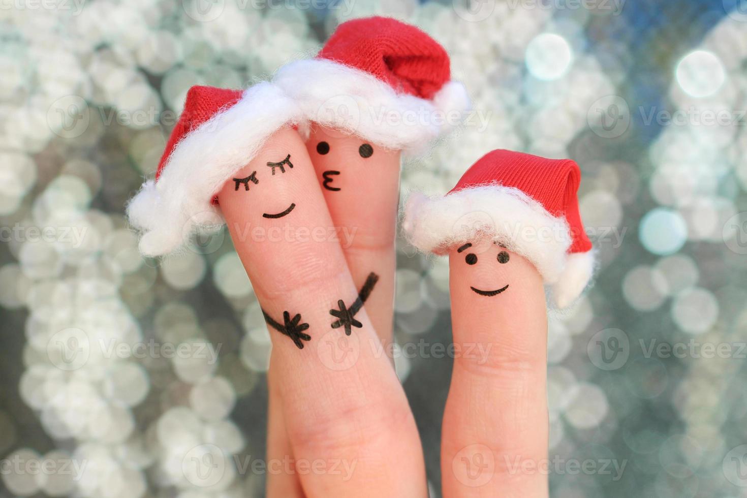 Fingers art of family celebrates Christmas. Concept of group of people smiling in new year hats. photo