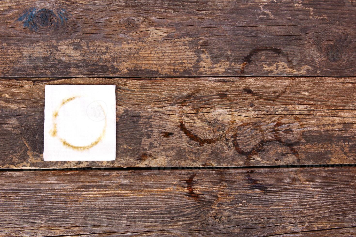 Trail from cup of coffee on napkin and on old wooden background. Top view. Flat lay. photo