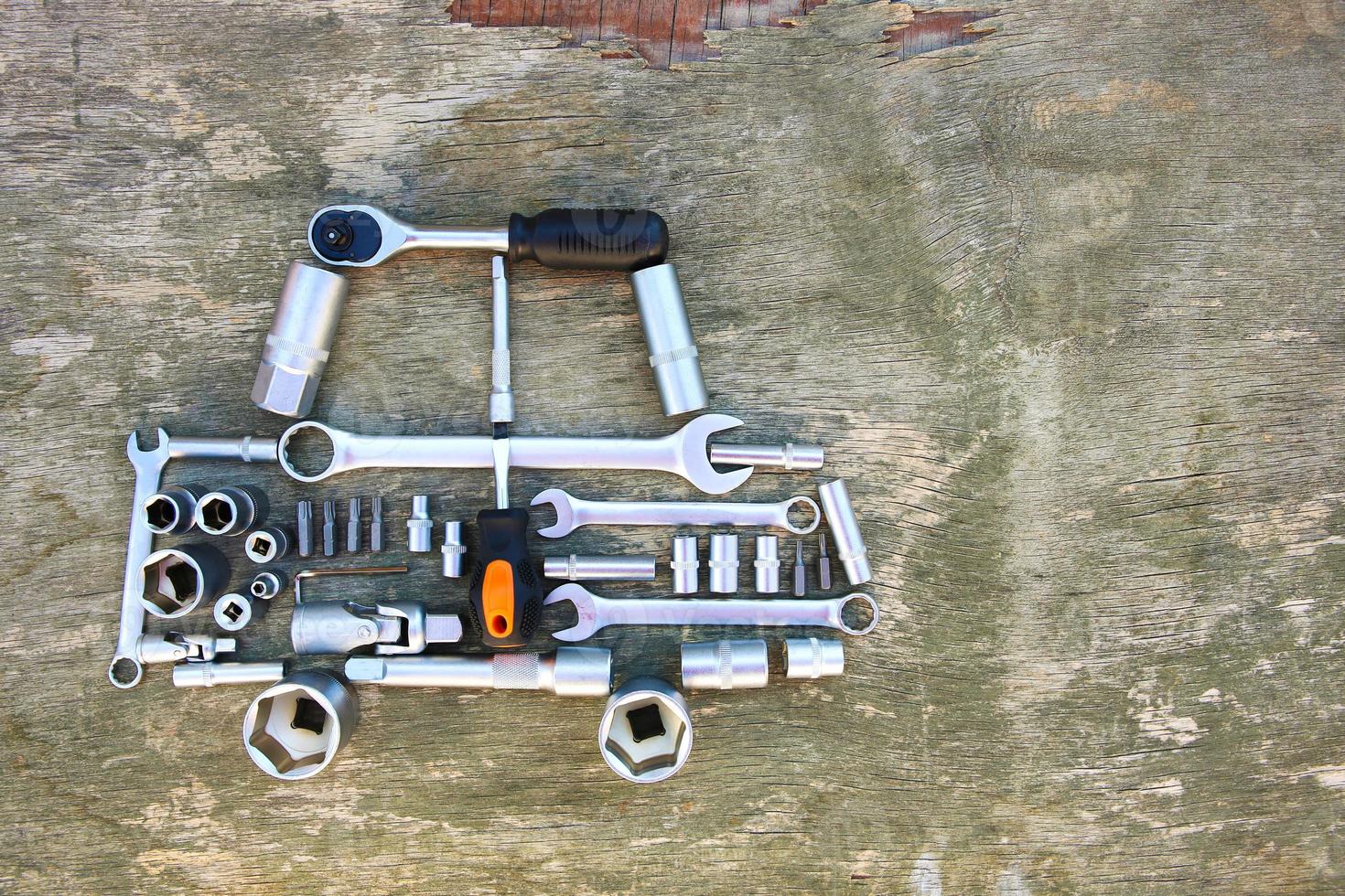 Tool to repair in form of car on wooden background. Top view. Flat lay. photo