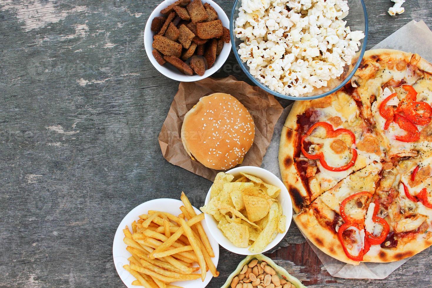 Fast food on old wooden background. Concept of junk eating. Top view. Flat lay. photo