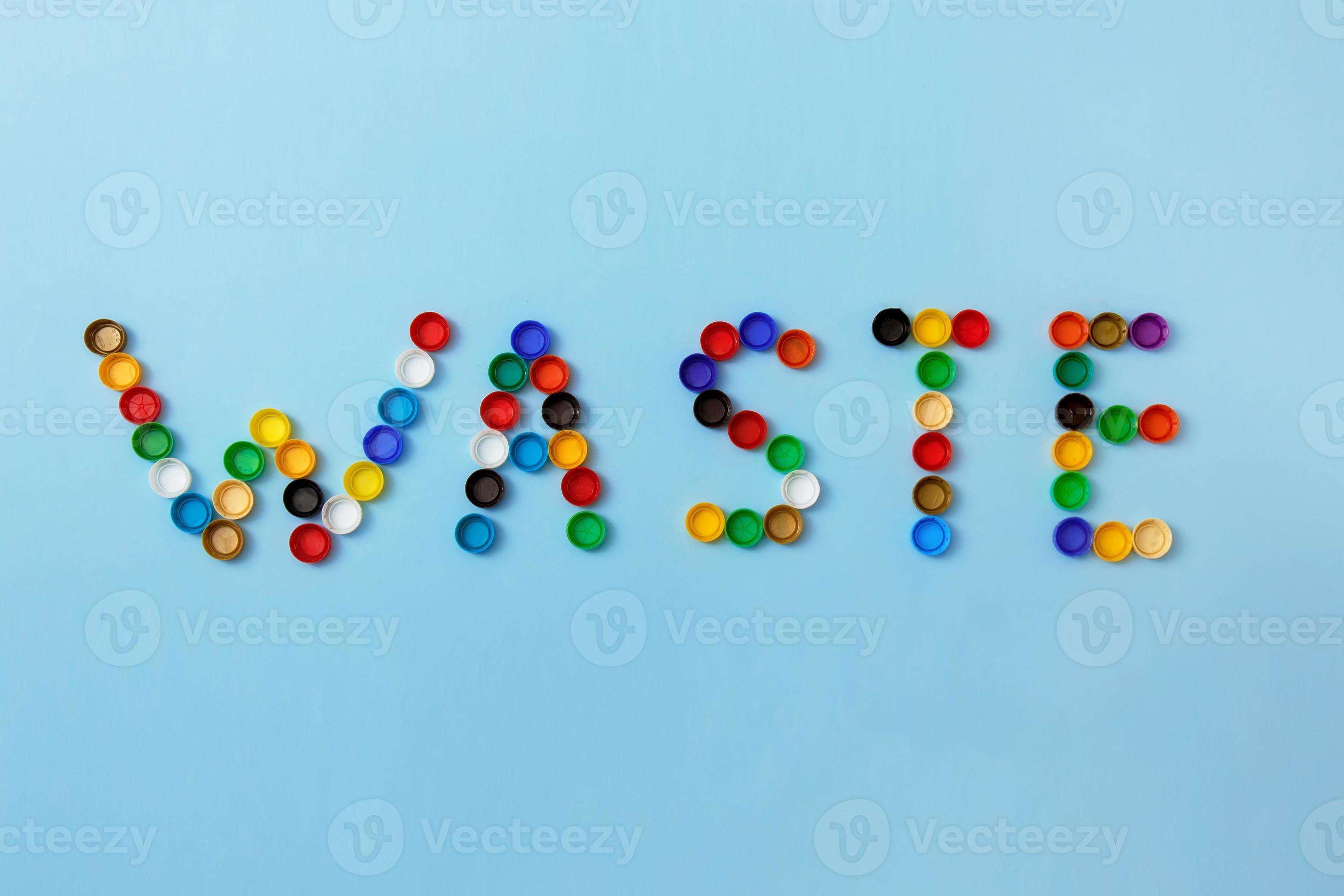 word waste is lined with plastic bottle caps on a blue background