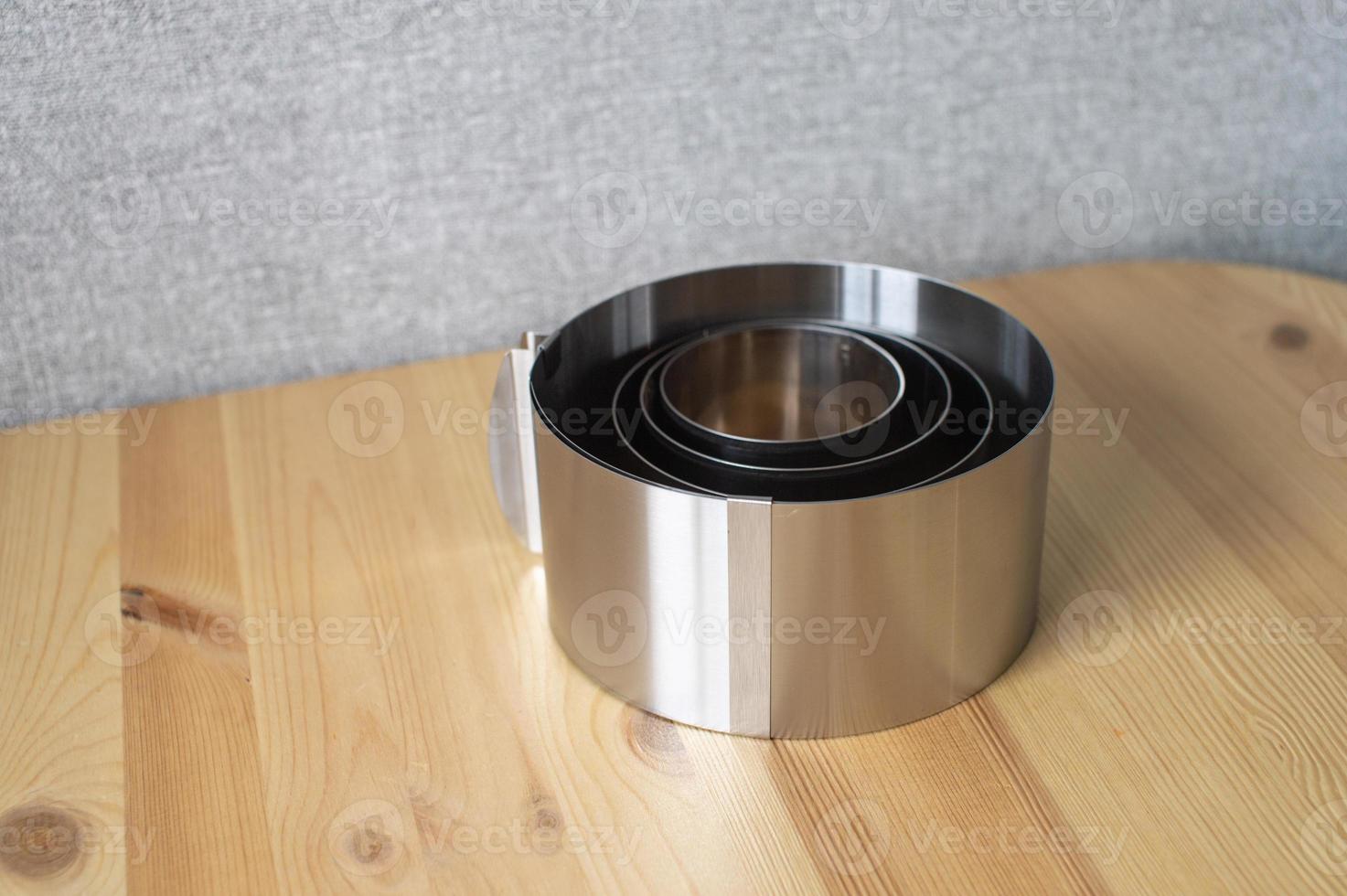 A set of tools for a confectioner. Round molds for baking cakes of different sizes on a wooden table photo