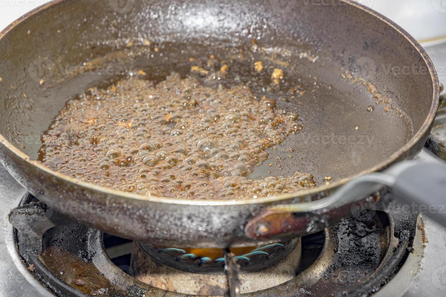 sugar caramelizing in a frying pan at gas stove in kitchen photo