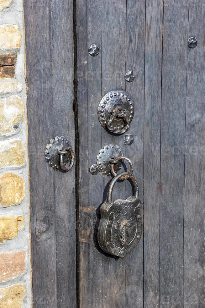 Door knocker and a big vintage padlock on the wooden door. True retro style. photo