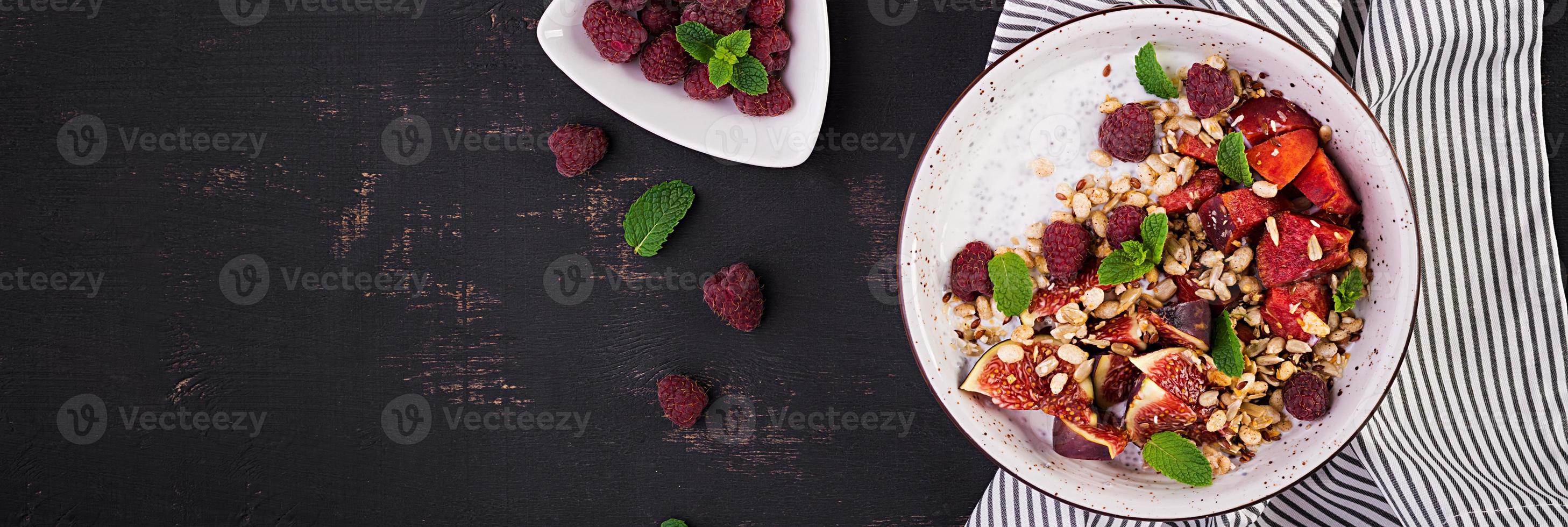 Chia seed pudding made with raspberries,  figs and mint on dark background.  The concept of good nutrition. Banner. Top view photo