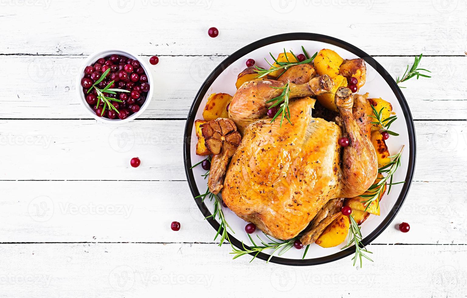 Roasted turkey garnished with cranberries on a rustic style table decorated  autumn leaf. Thanksgiving Day. Baked chicken. Top view photo