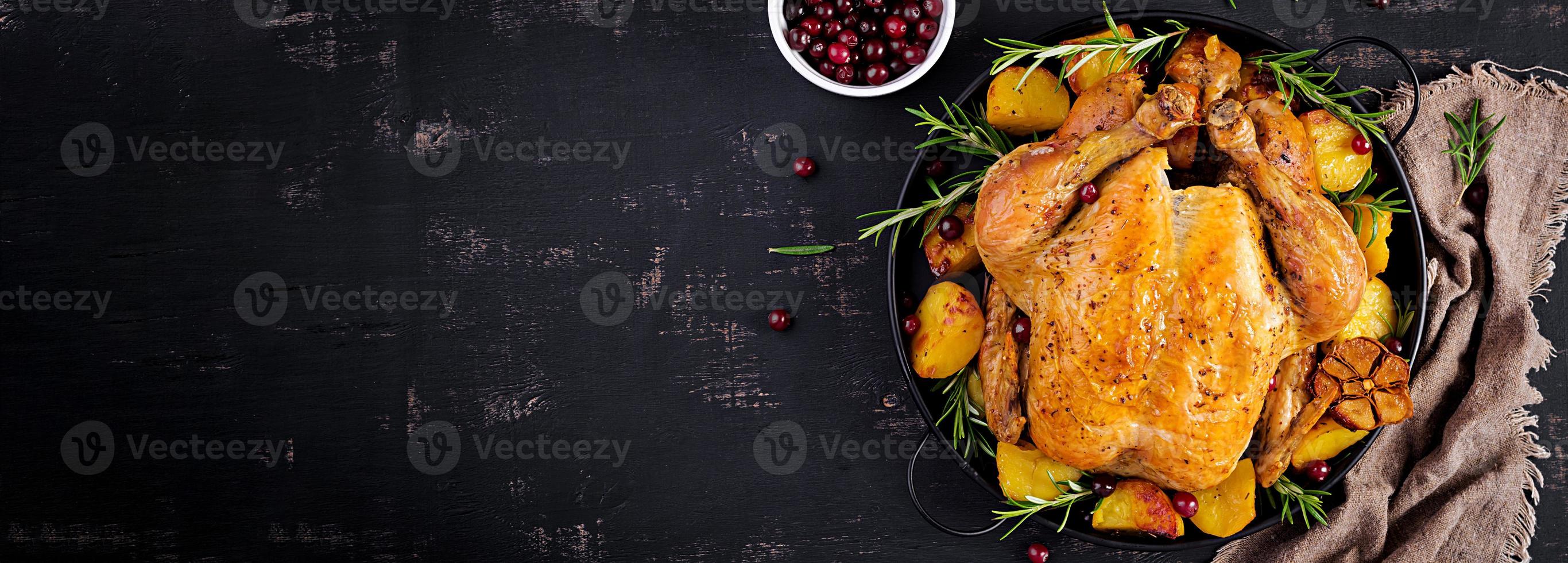 Baked turkey or chicken. The Christmas table is served with a turkey, decorated with bright tinsel. Fried chicken. Table setting. Christmas dinner. Banner. Top view photo