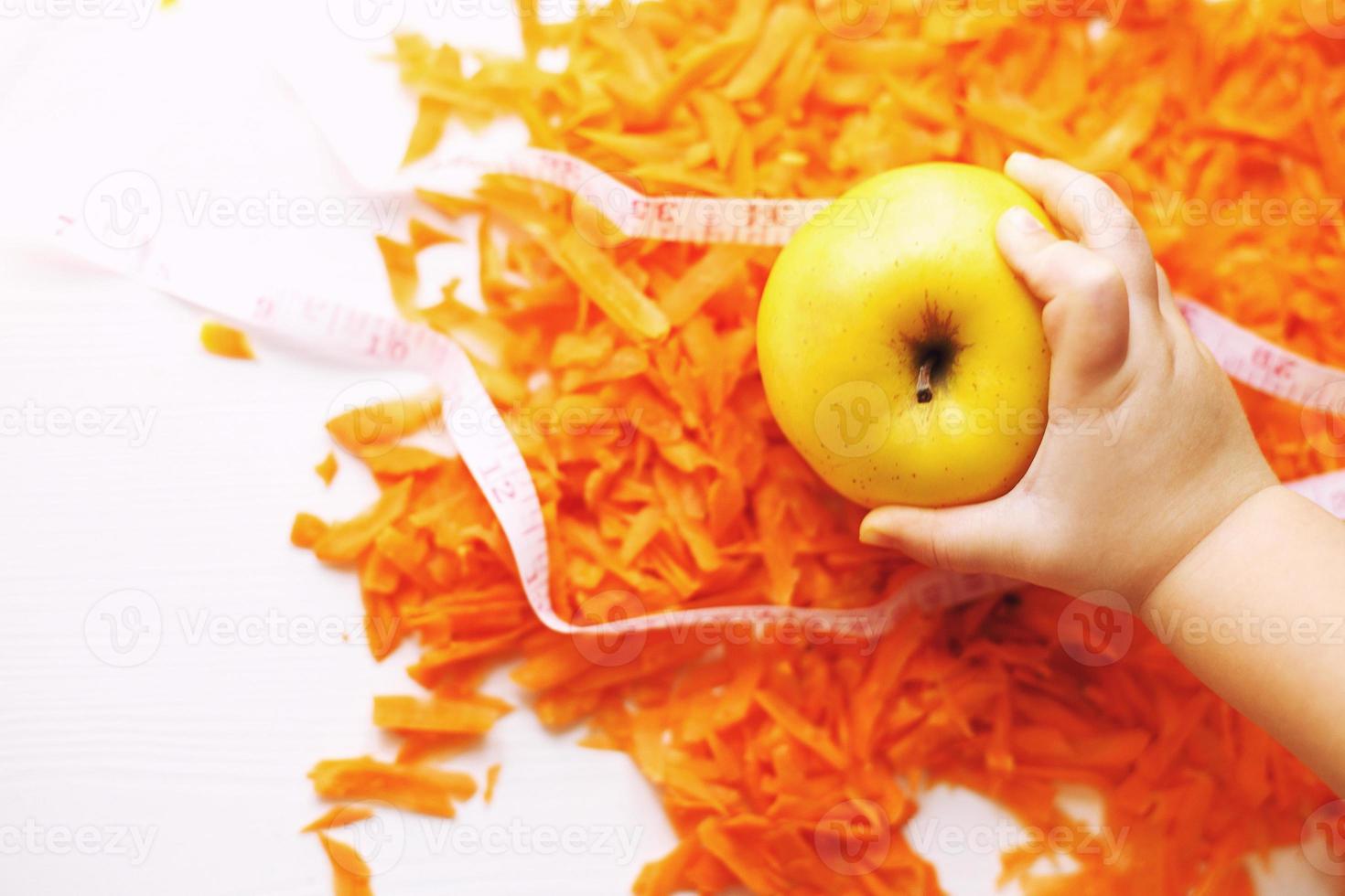chopped carrots and apple. child takes an apple. fruits and vegetables healthy food for diet photo
