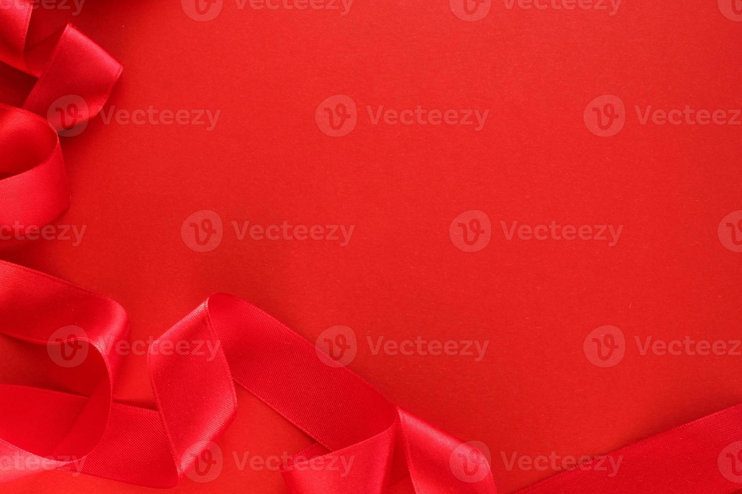 Curved wavy silk satin red ribbon on   background with copy space for text. Holiday, celebration, anniversary, birthday gift decoration concept. Idea for greeting card, sale banner photo