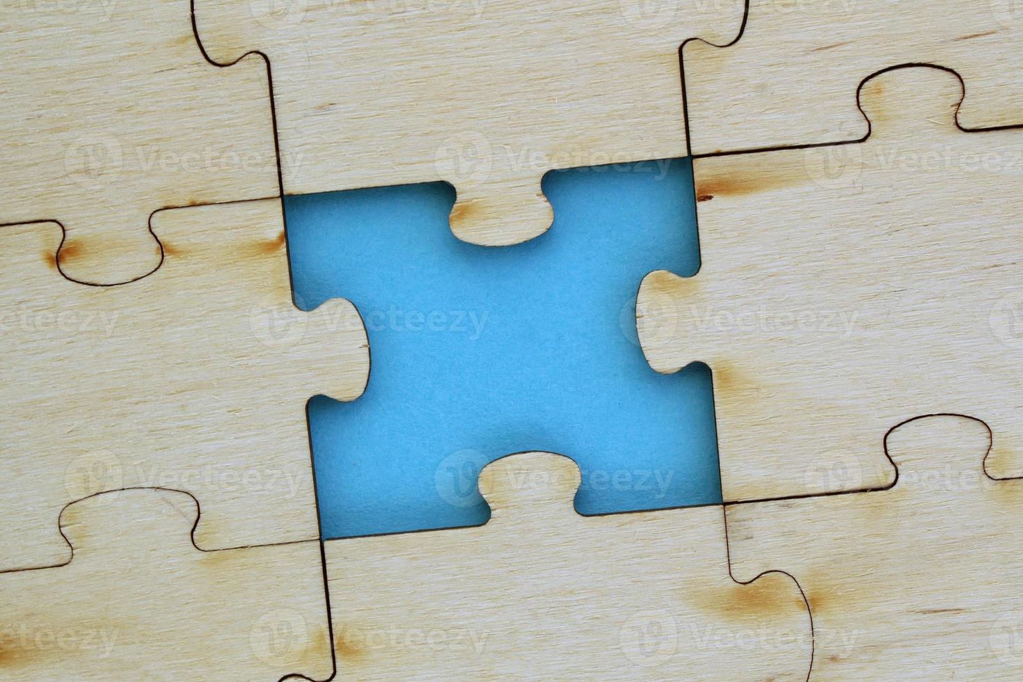 Incomplete and absence wooden puzzle piece with blue backdrop. Missing piece. Mental health concept. Symbol of problem solving. Business creative solution. Communication idea. Hobby, play, fun game photo