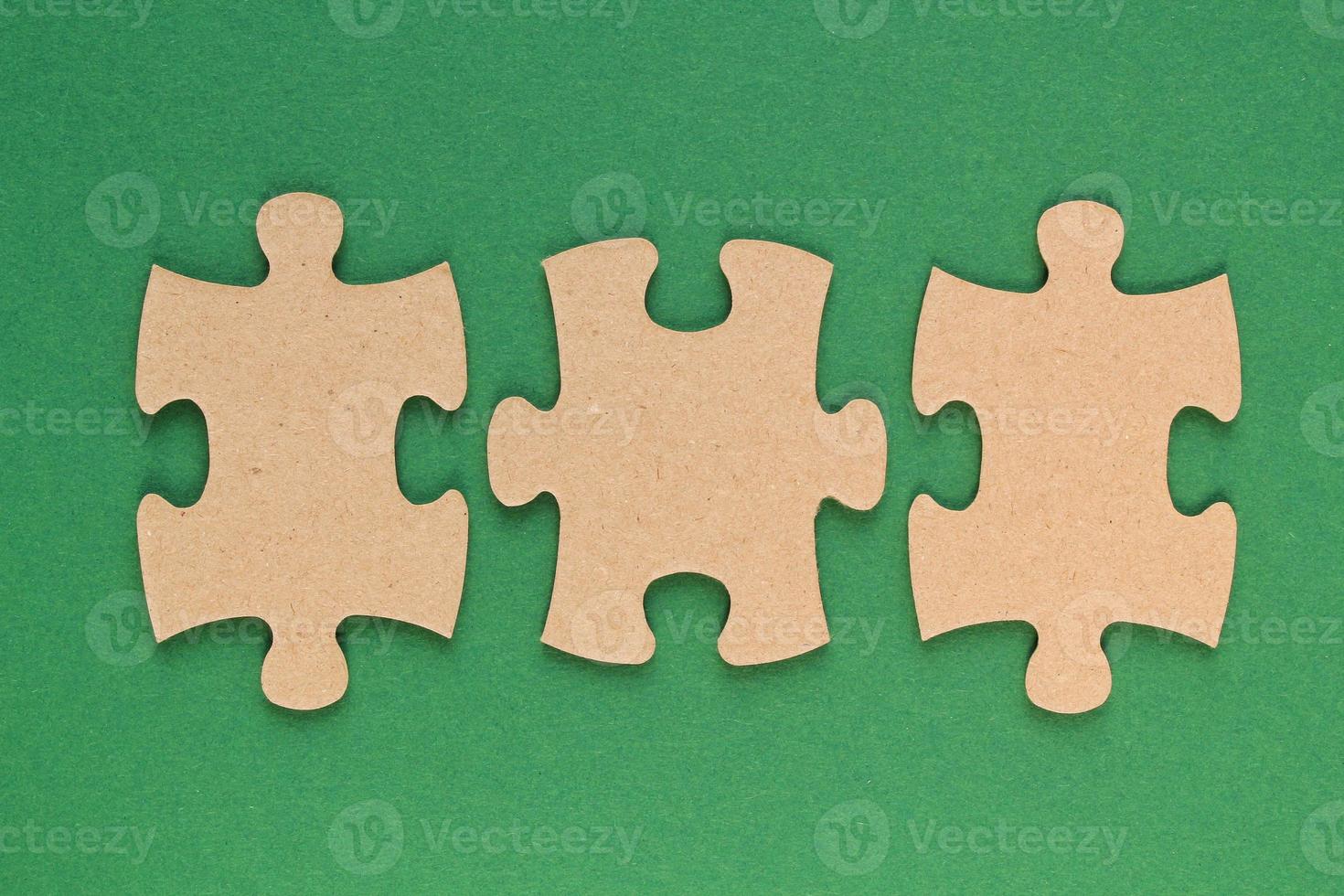 Carton mosaic game details of jigsaw puzzle elements on green background. Completing task or solving problem concept. World mental health day, autism awareness day. Global communication. Hobby, play photo