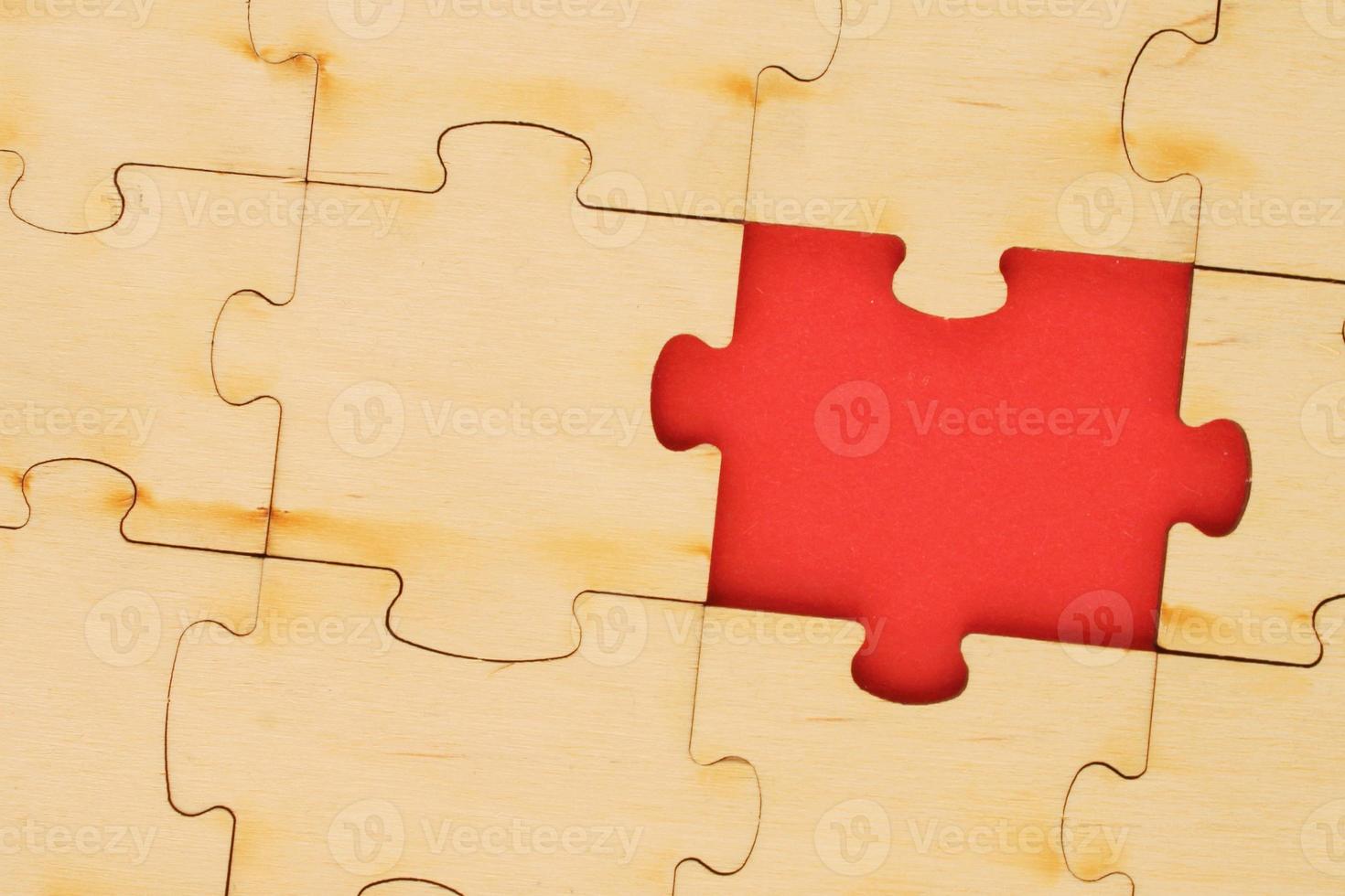 Incomplete and absence wooden puzzle piece with red backdrop. Missing piece. Mental health concept. Symbol of problem solving. Business creative solution. Communication idea. Hobby, play, fun game photo