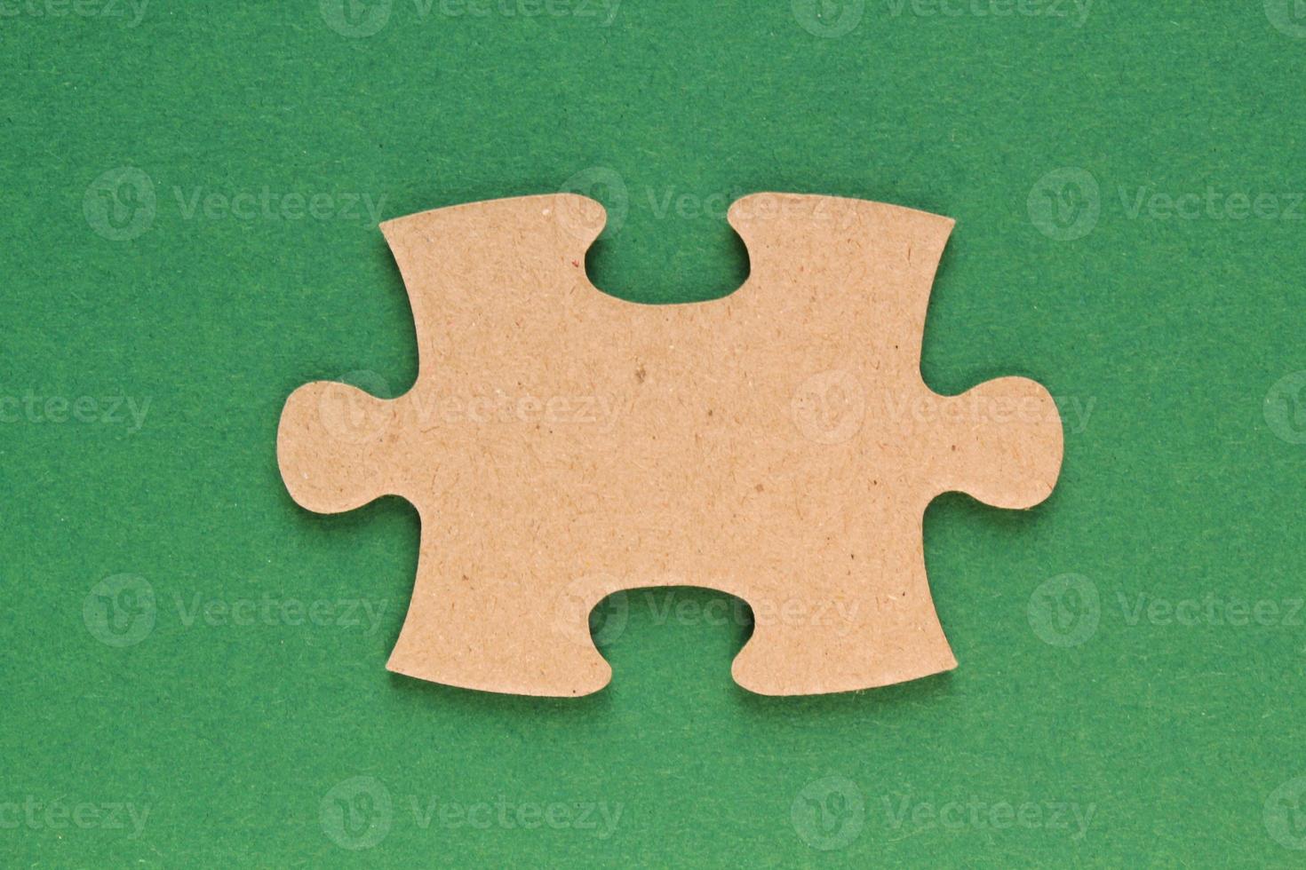 Carton mosaic game detail of jigsaw puzzle element on green background. Completing task or solving problem concept. World mental health day, autism awareness day. Global communication. Hobby, play photo