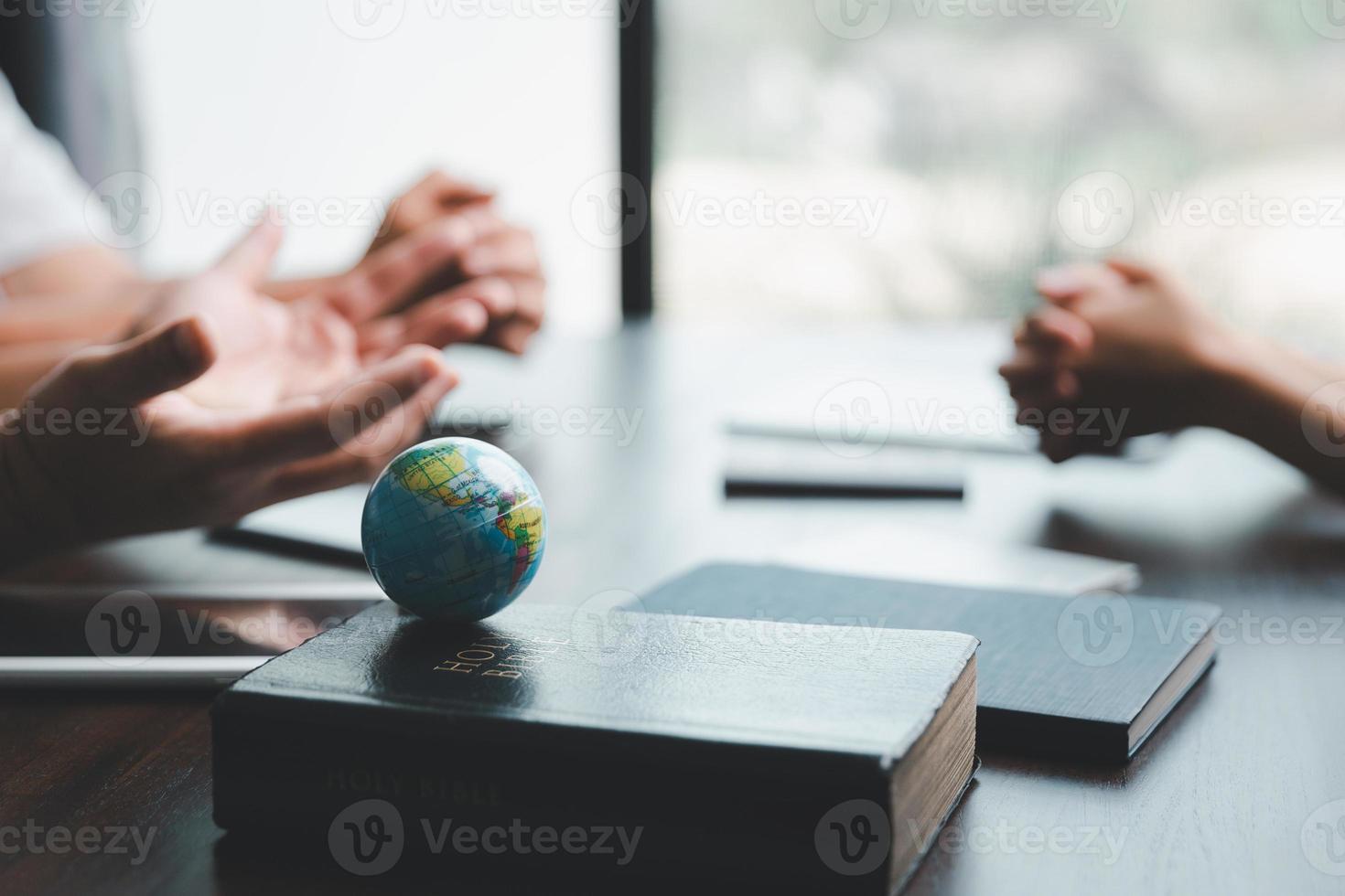 Concept of Christian ministry. Small groups pray together for Christian mission. Mission to spread the gospel and religion of Christianity around the world. hands praying with bible on wooden table. photo