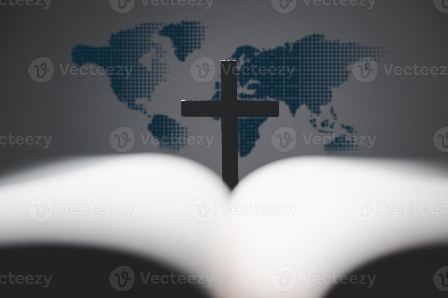 cruzar con abierto santo Biblia en mesa con mundo mapa difuminar antecedentes. misión evangelización y evangelio en mundo. Copiar espacio para texto, cristiano antecedentes para genial comisión o tierra día concepto. foto