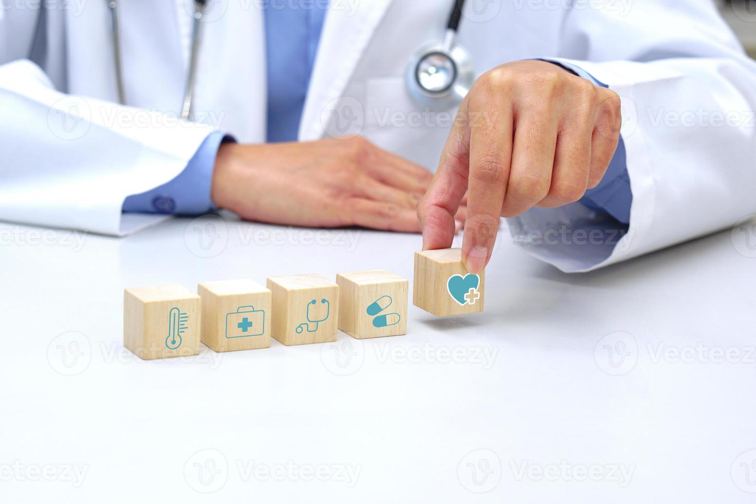 mano sosteniendo un cubo de bloque de madera con símbolo de icono médico sanitario. concepto médico y de salud. foto