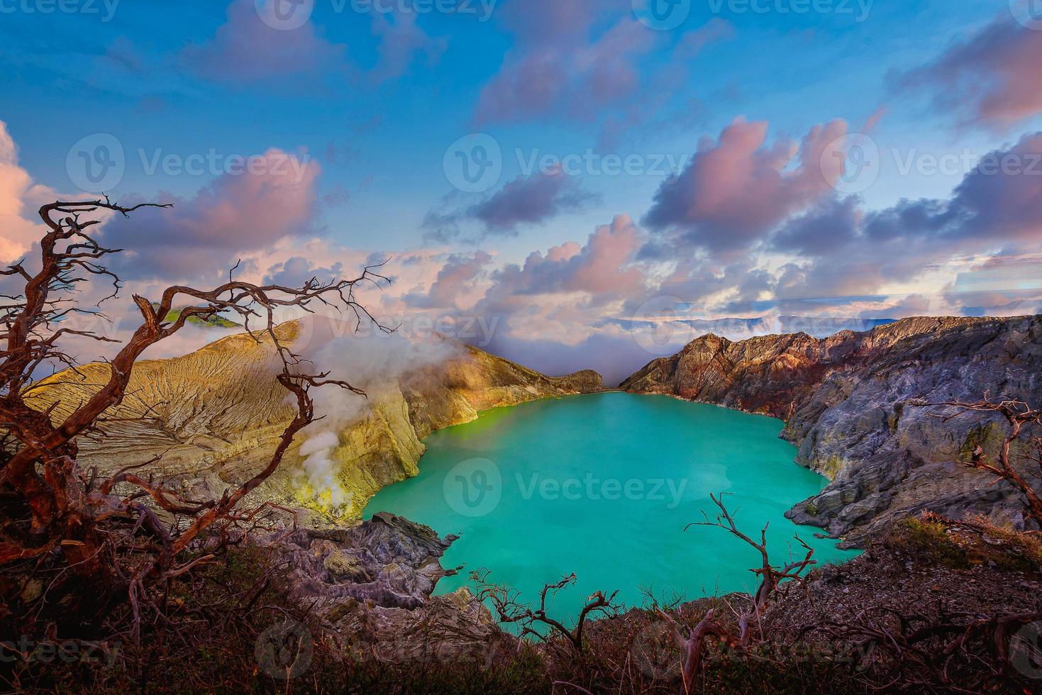 Kawah Ijen volcano with Dead trees on blue sky background in Java, Indonesia. photo