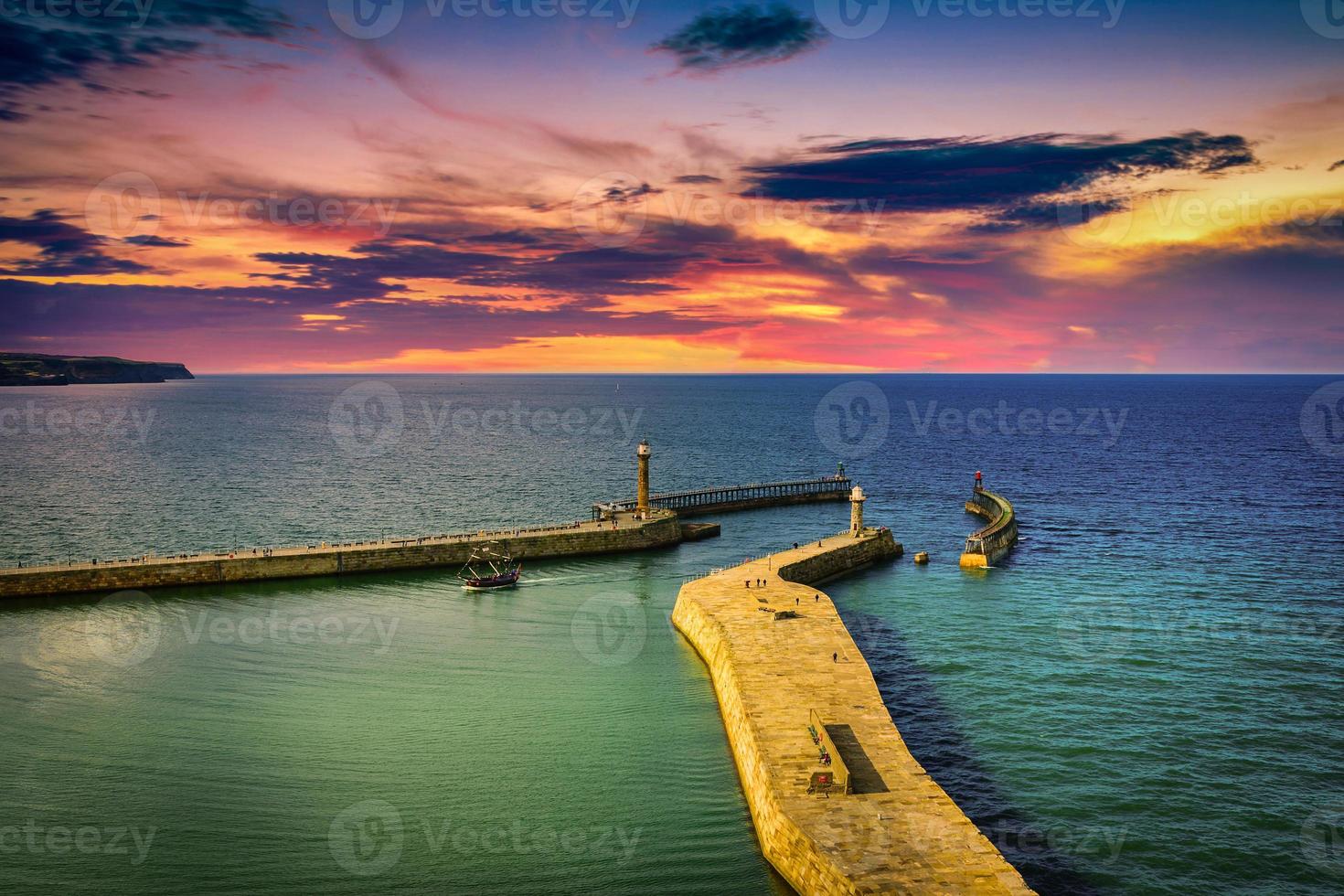 el puerto y faros a puesta de sol en whitby abadía, norte yorkshire, Reino Unido foto