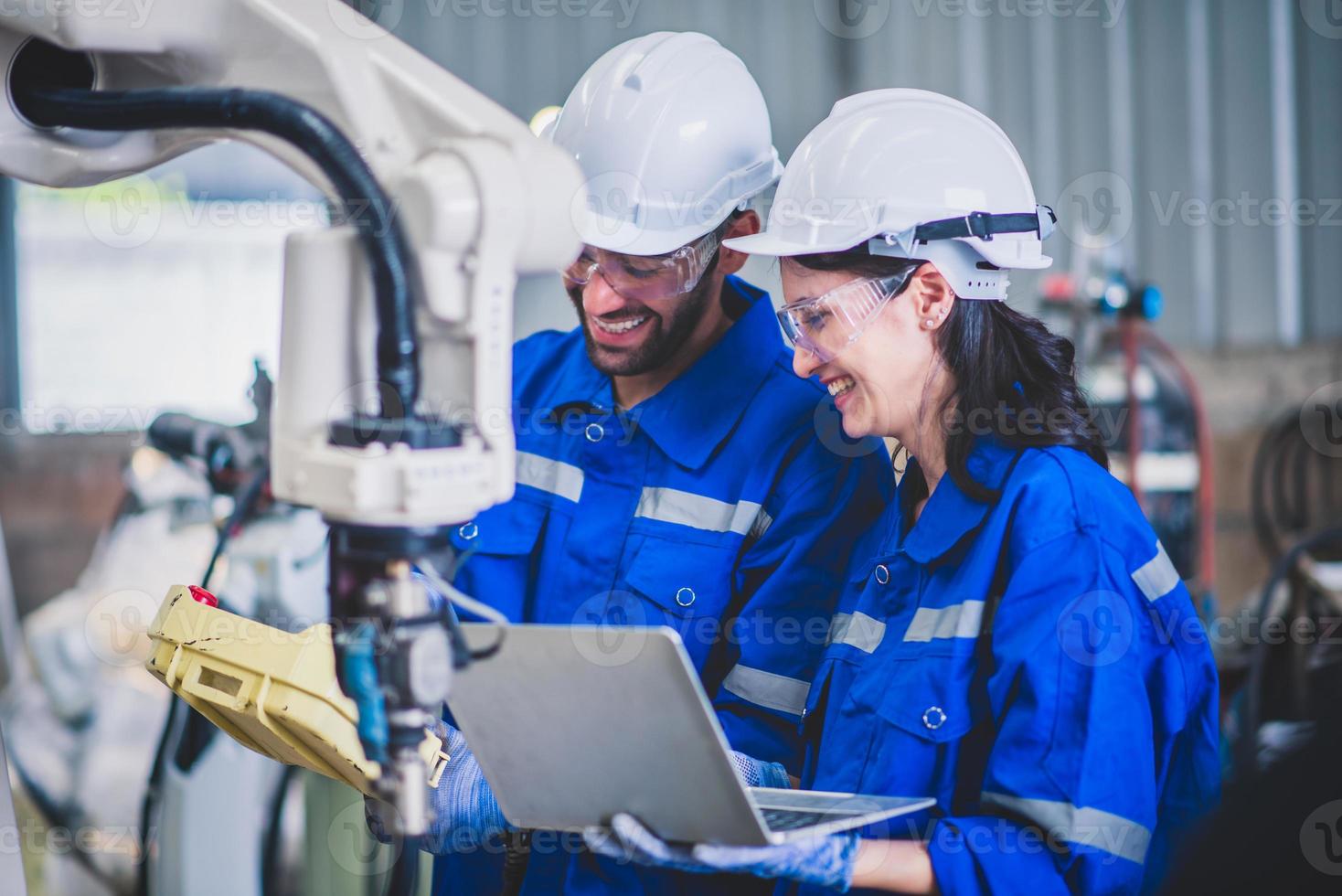 Engineers mechanic using computer controller Robotic arm for welding steel in steel factory workshop. Industry robot programming software for automated manufacturing technology photo