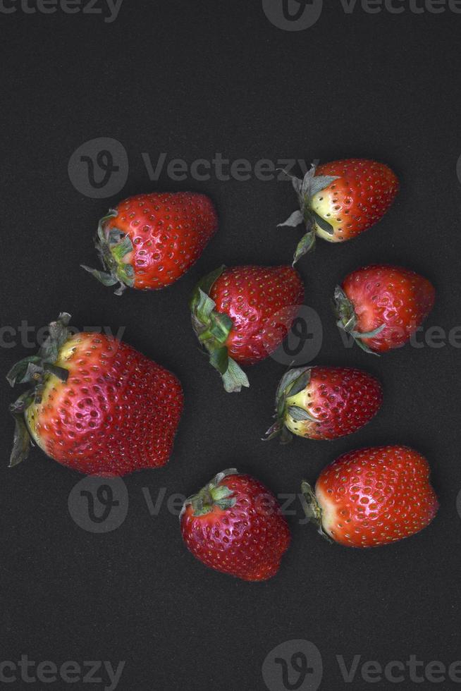 Delicious large red strawberries on a black background. Red berry. Berry Victoria. photo