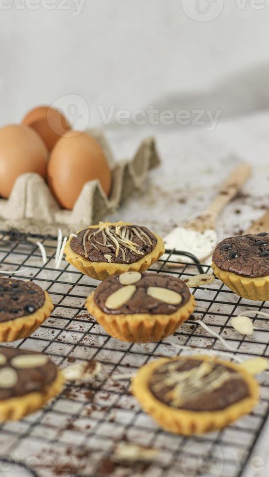 Small chocolate pie with almonds topping served on a cake rack, tastes sweet and savory. Food concept photo. photo