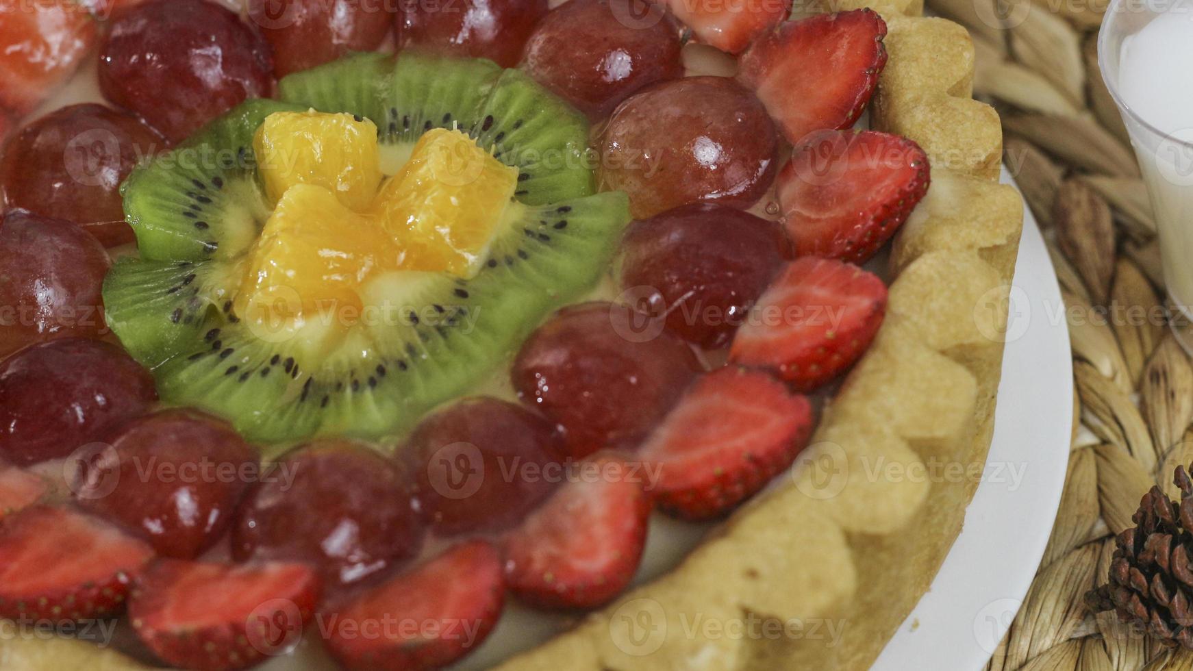 big fruit pie with toppings of strawberries, grapes, kiwi and pineapple. savory, sweet and fresh. Food concept photo. photo