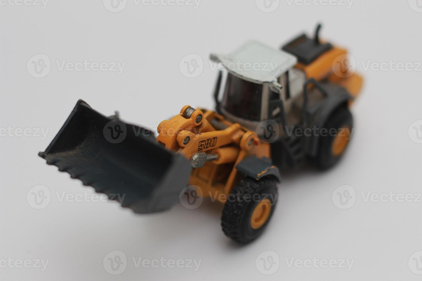 a close up of miniature orange wheel loader toy photo