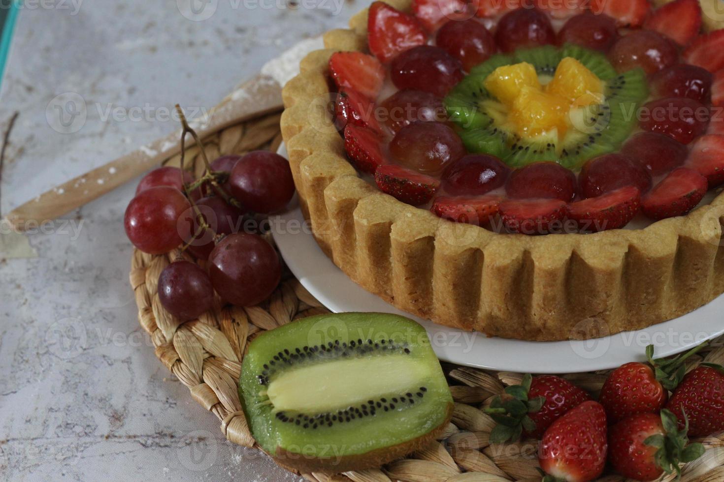 big fruit pie with toppings of strawberries, grapes, kiwi and pineapple. savory, sweet and fresh. Food concept photo. photo