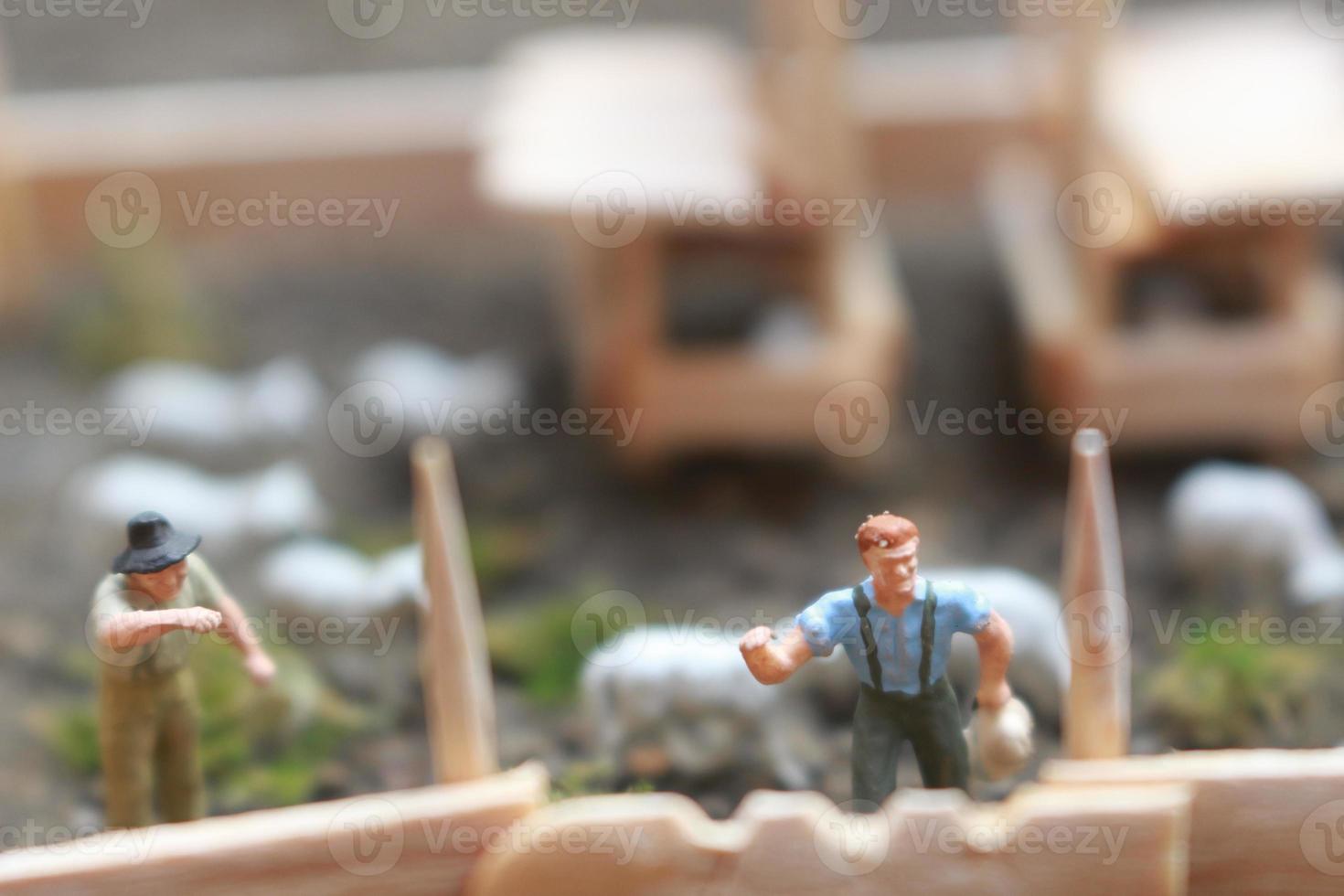 un cerca arriba de miniatura figura de un cabra pastor alimentación en un de madera jaula. pastor concepto. foto