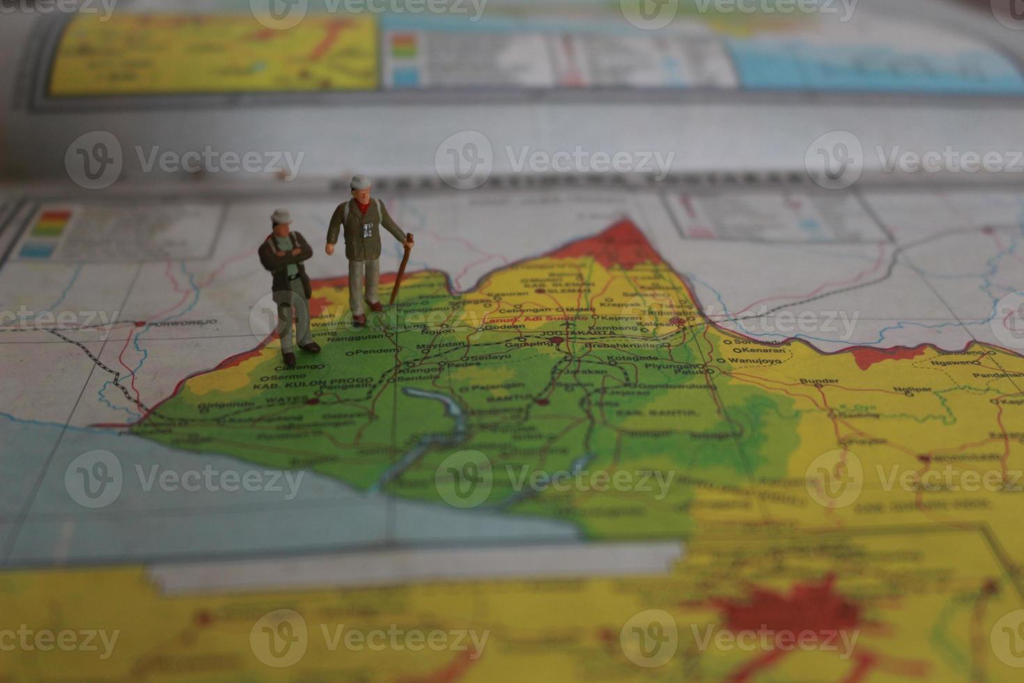 miniature figure of an explorer posing on a map or atlas photo