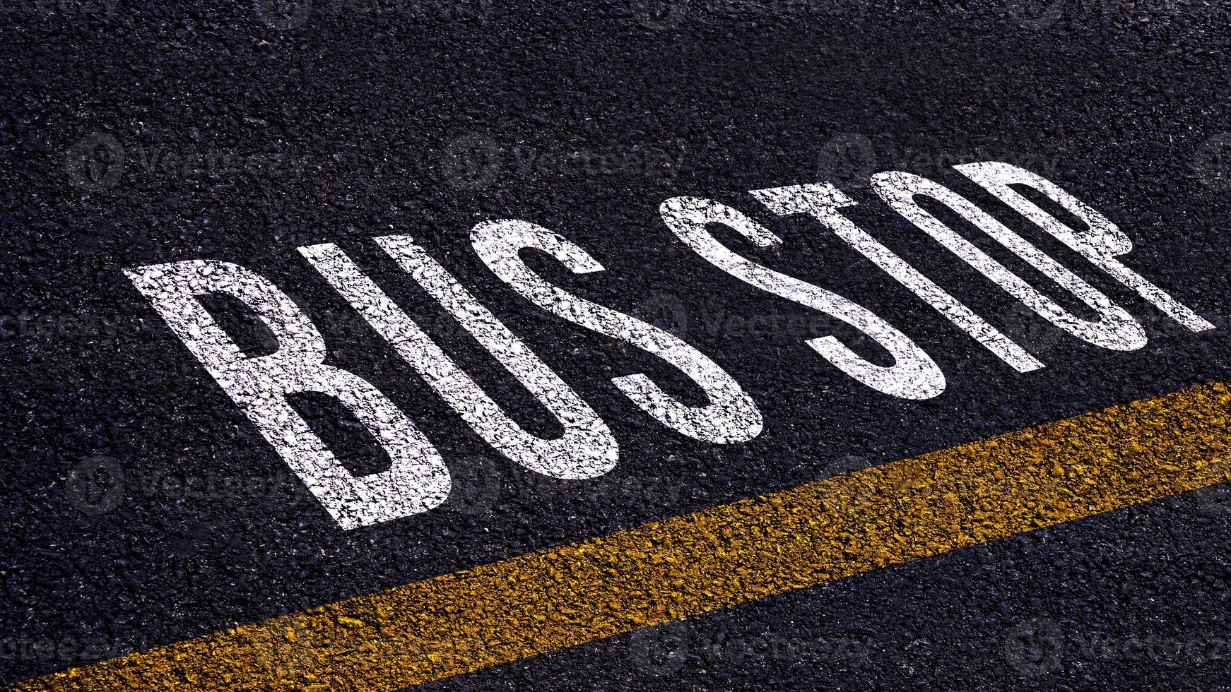 Bus stop text written and yellow line on the road in middle of the asphalt road, Bus stop word on street. photo