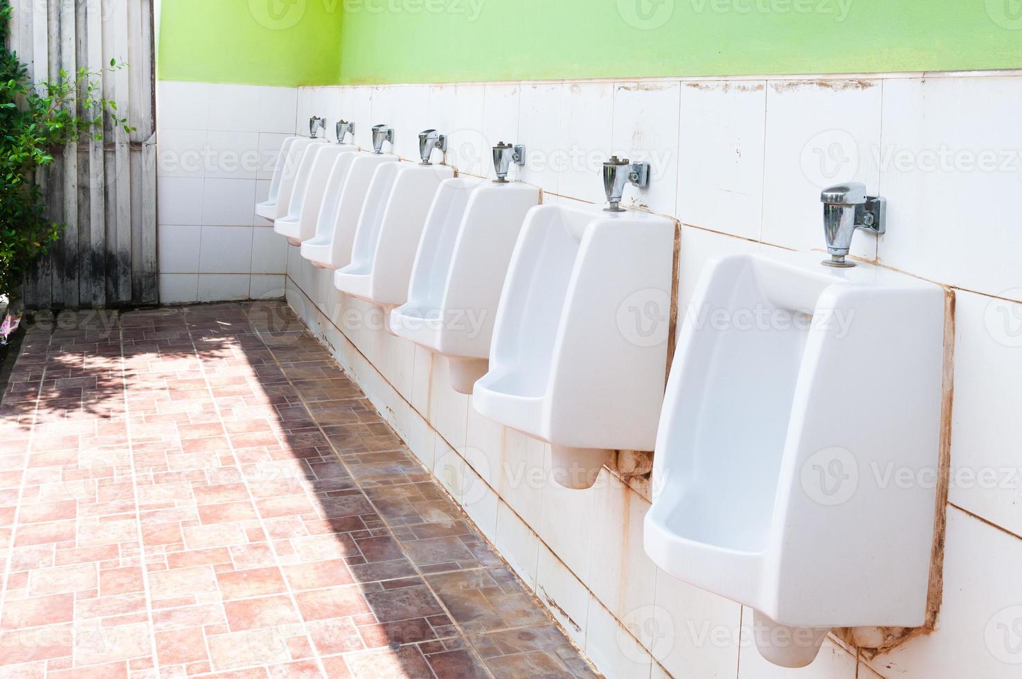 line of white porcelain urinals in public toilets, dirty toilets outdoor photo