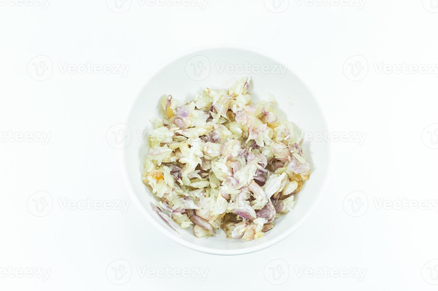 Chopped and slices of garlic in a white cup isolated on white background,top view photo