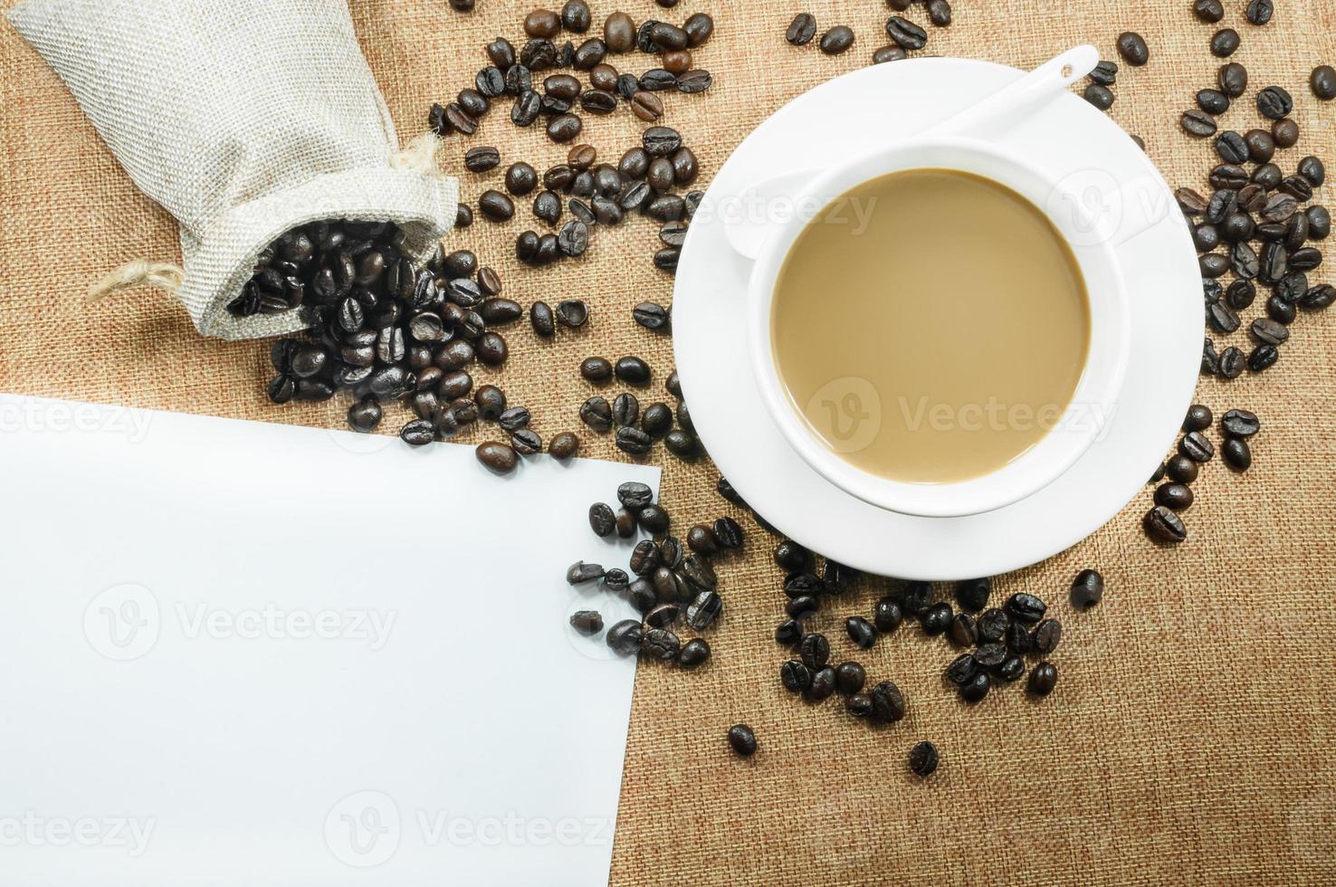 taza de Fresco café con café frijoles en arpillera calentar taza en marrón antecedentes parte superior ver con gratis espacio para texto foto