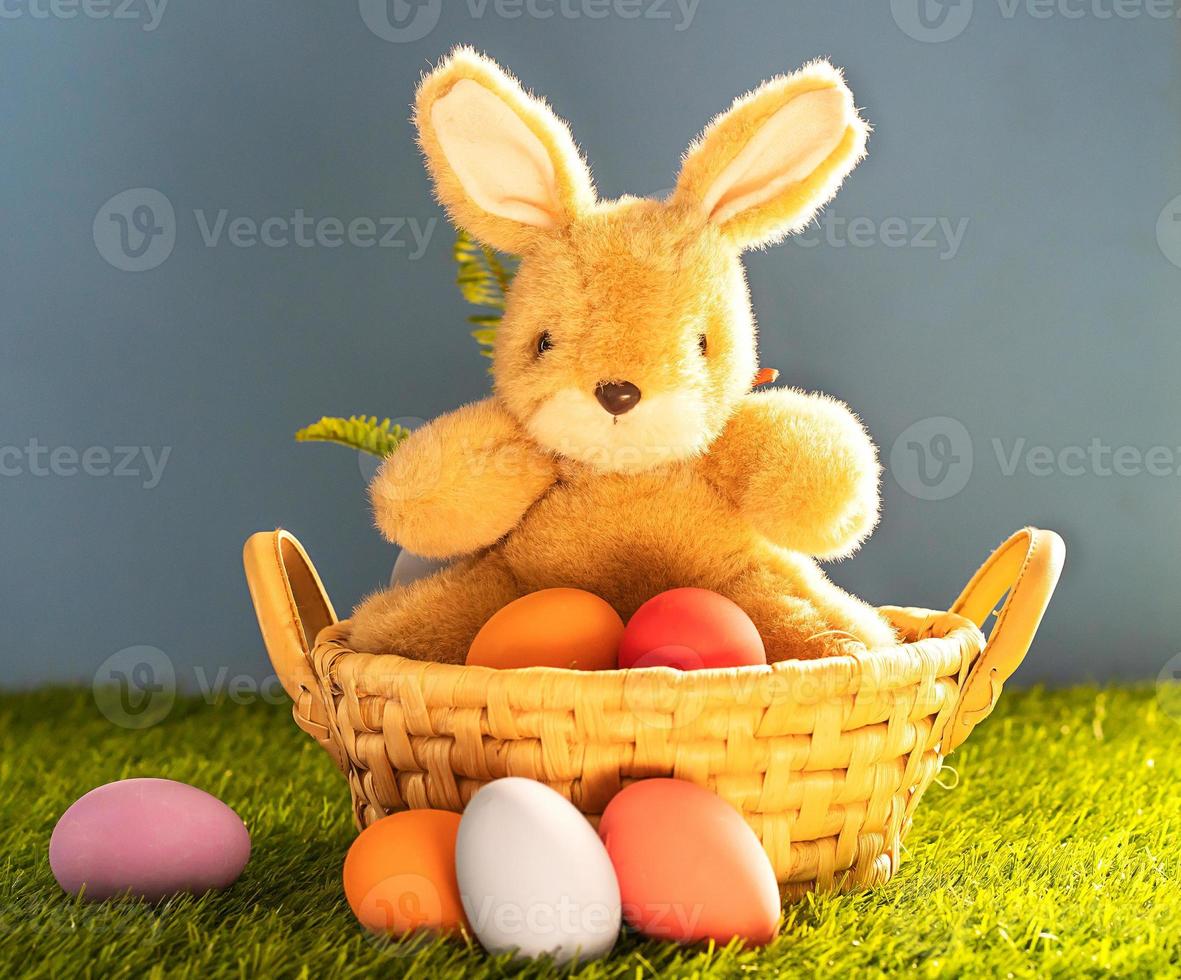 Bunny toy and Easter eggs in basket photo