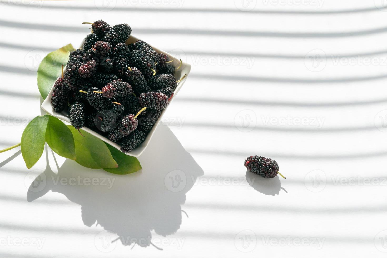 Fresh ripe mulberries fruite in a plate on a white background photo