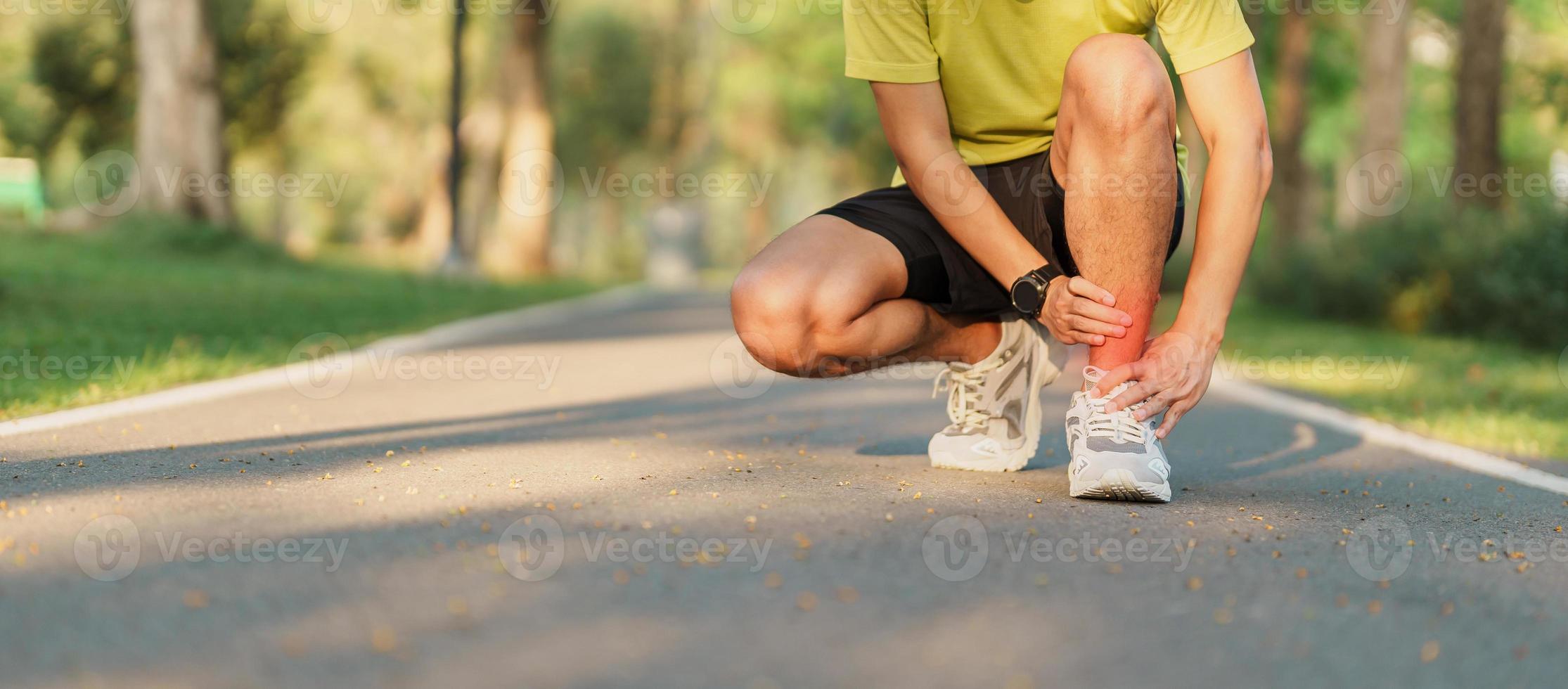 Young adult male with his muscle pain during running. runner man having leg ache due to Ankle Sprains or Achilles Tendonitis. Sports injuries and medical concept photo