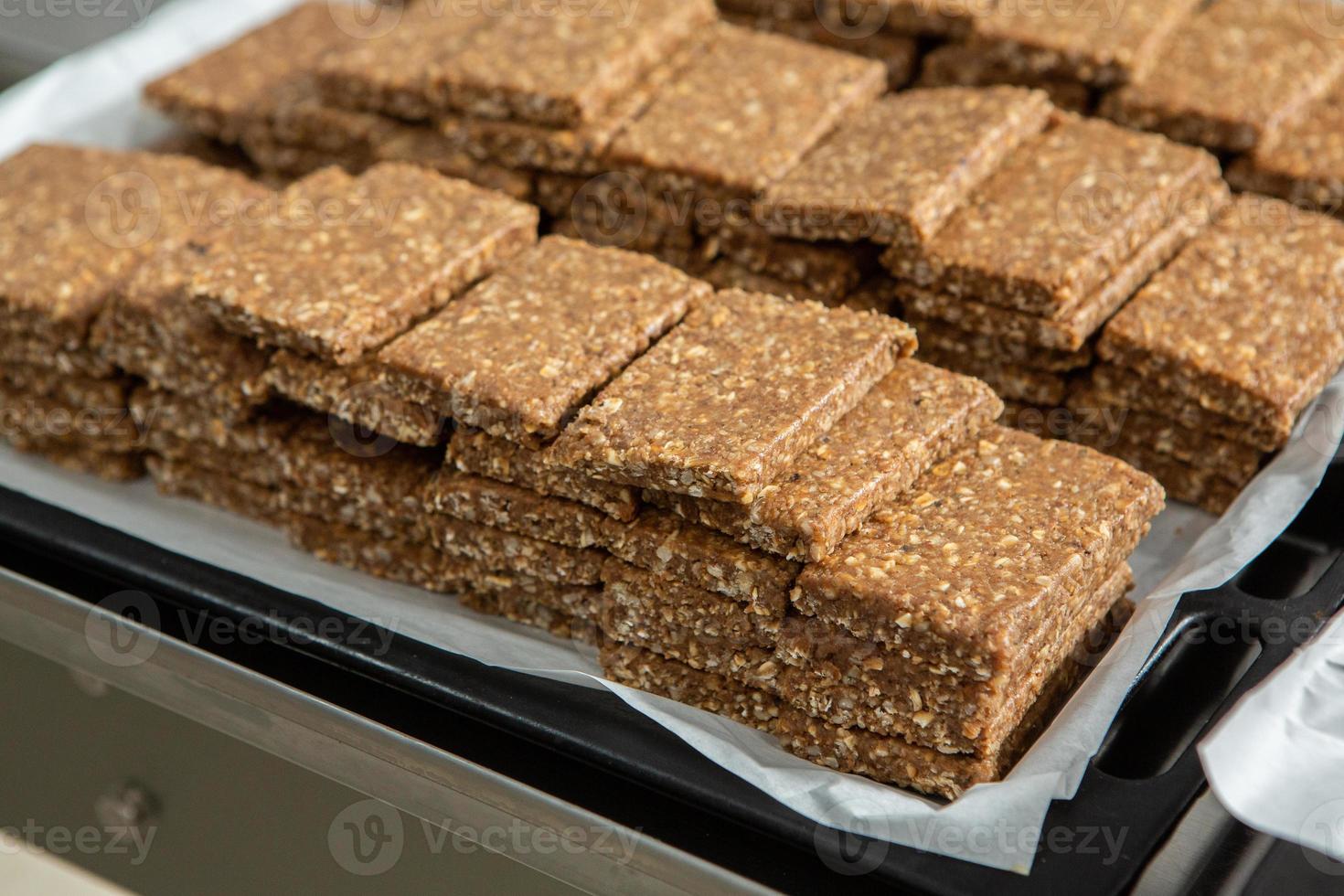 Assortment of cereal or protein bars that leave the assembly line at the factory. Healthy pre or post workout snacks with fruits, nuts and berries. photo