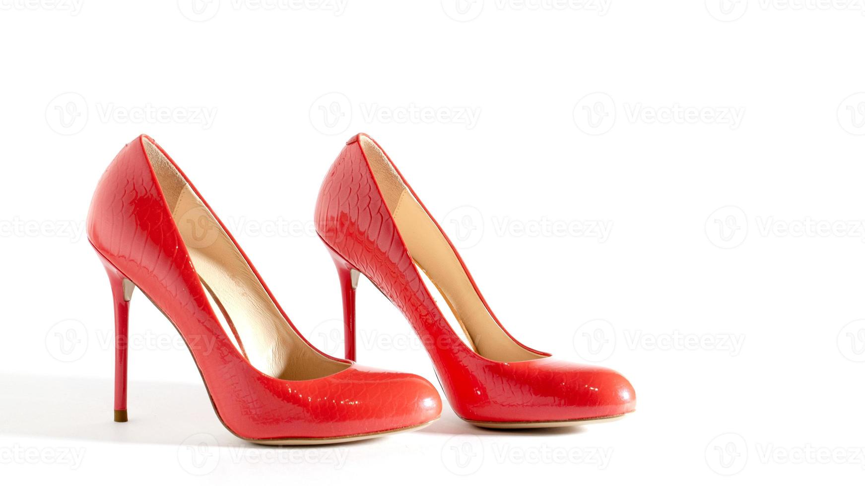 Bright red shoes on the white background. Side view picture. Beautiful high heels shoes. Element for design. Space for text. photo