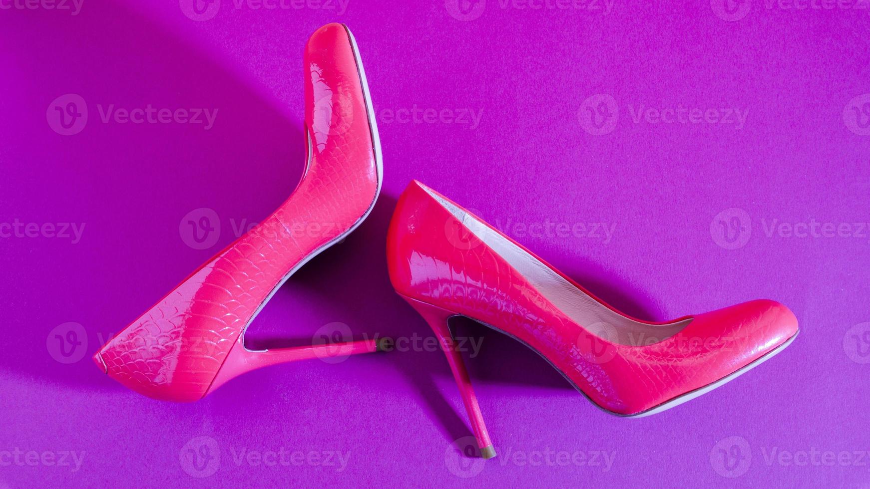 Elegant classic shoes close-up. Bright pink high heeled shoes. Pink and violet background. photo